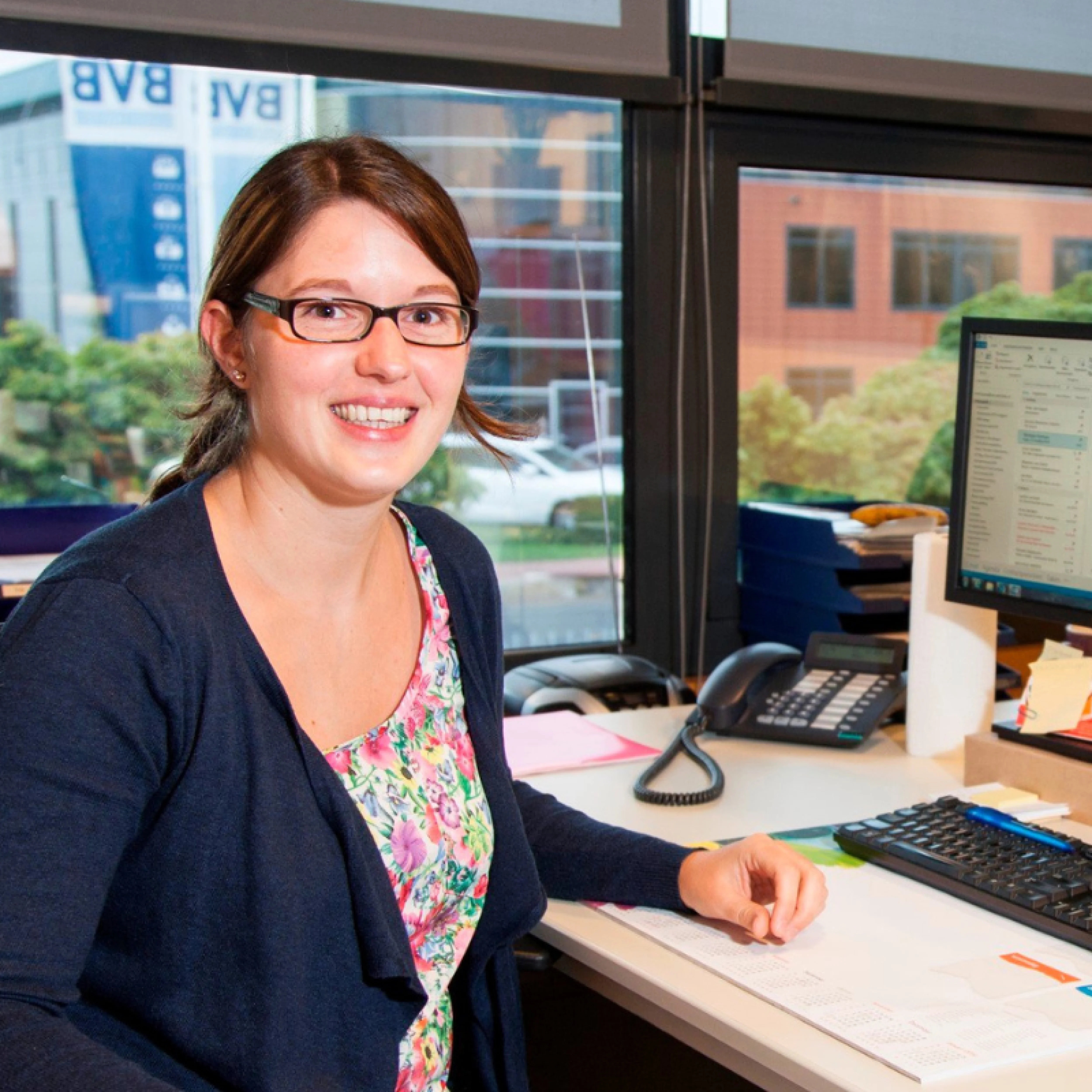 Een vrouw zit aan een bureau, bezig met haar werk bij Kekilla BVB